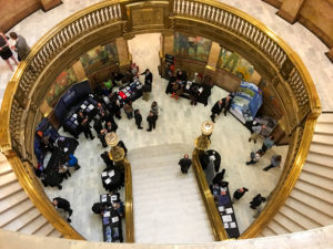 Birds eye view looking down at the booths at Aerospace Day in the Colorado State Capitol building.